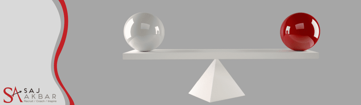 A white and red ball balancing on a pyramid scale