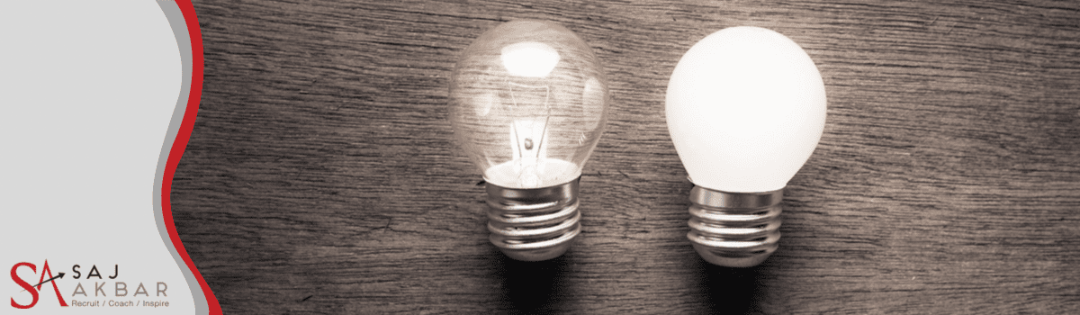 2 light bulbs on a table top, 1 looks lit